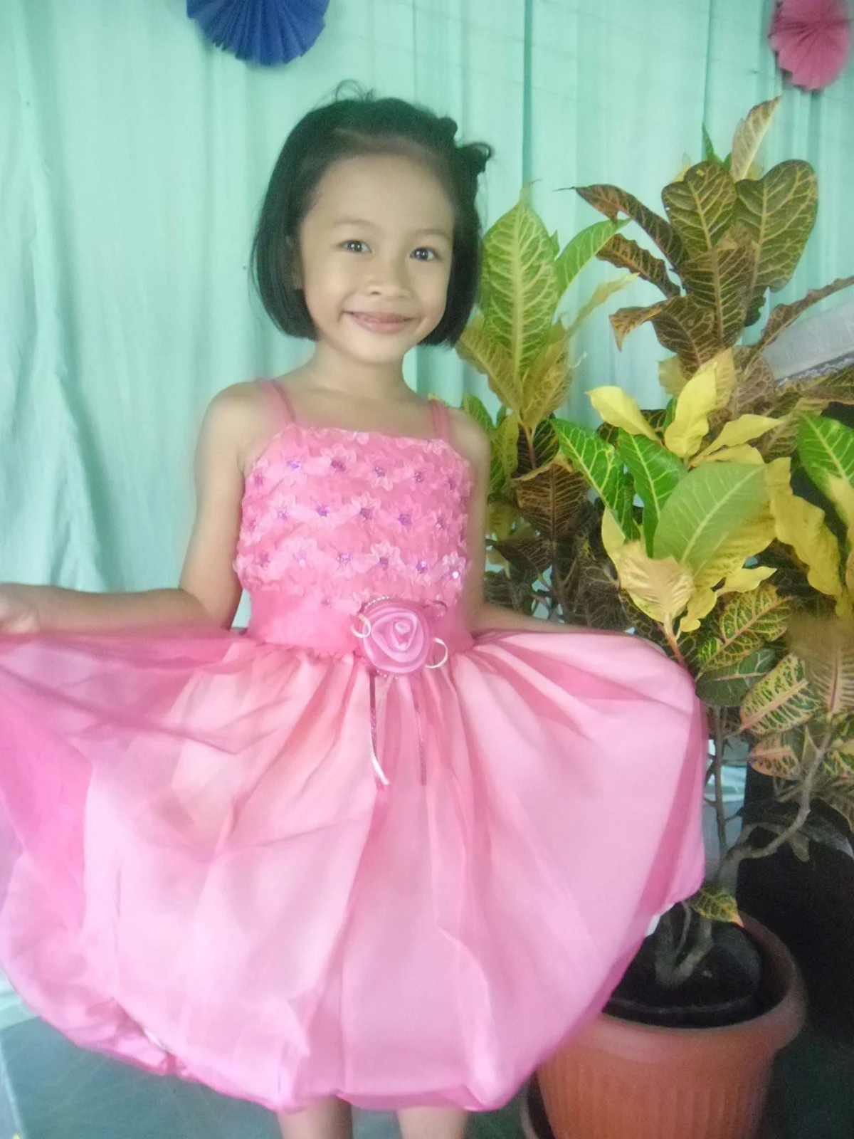 Young Gilly smiling in a pink dress